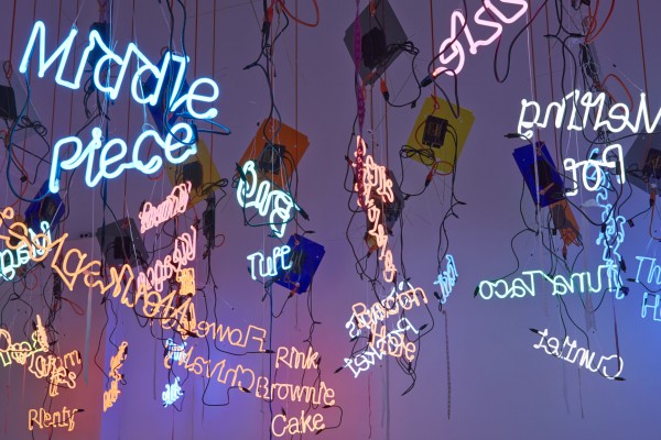 A photo of hanging neon signs that make up "My Madinah: In pursuit of my hermitage…" by Jason Rhoades