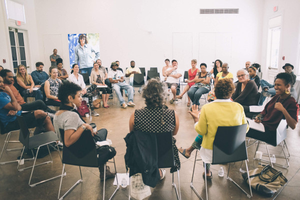 A photo of Artists-in-Residence Cecelia Givens, Philemona Williamson, and Heather Hart speaking to a seated audience