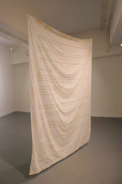 A photograph of a suspended textile installation in a gallery.
