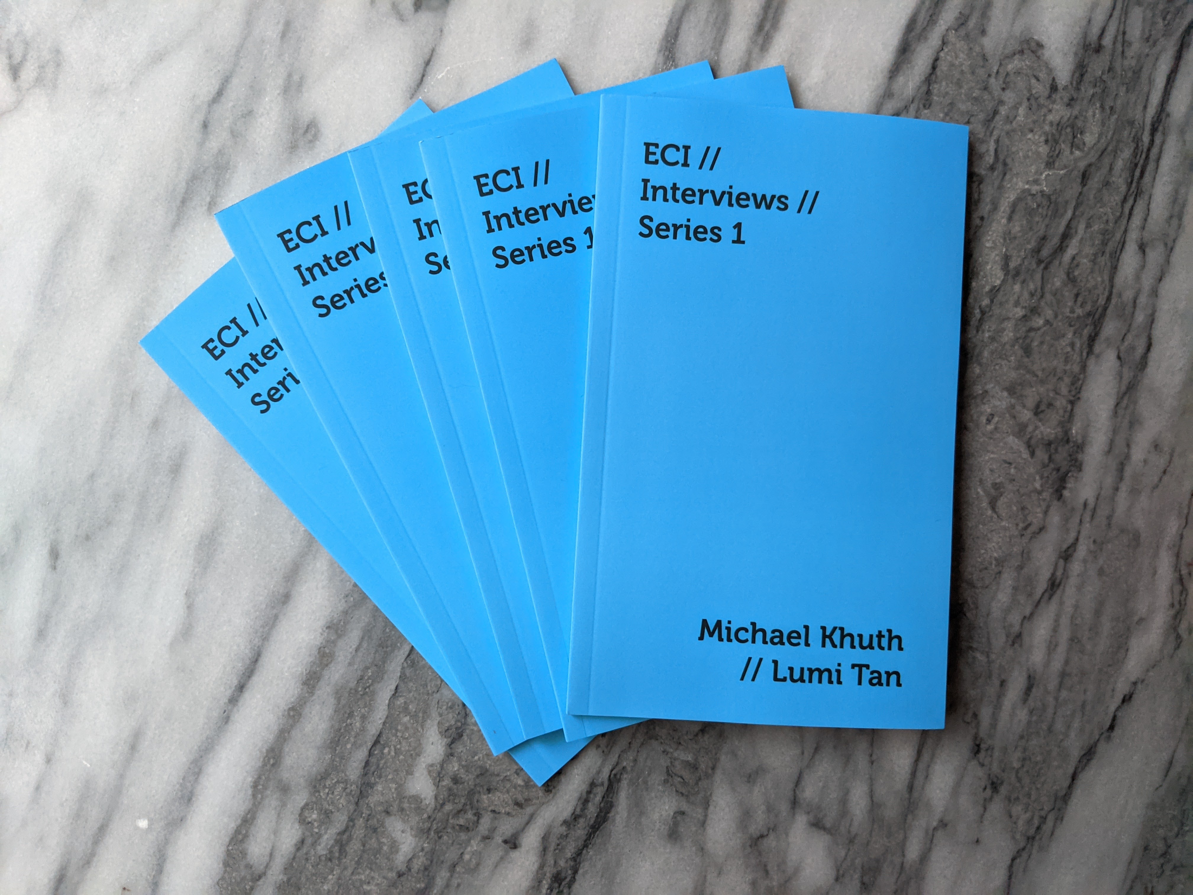 Photograph of a stack of booklets by Michael Khuth and Lumi Tan