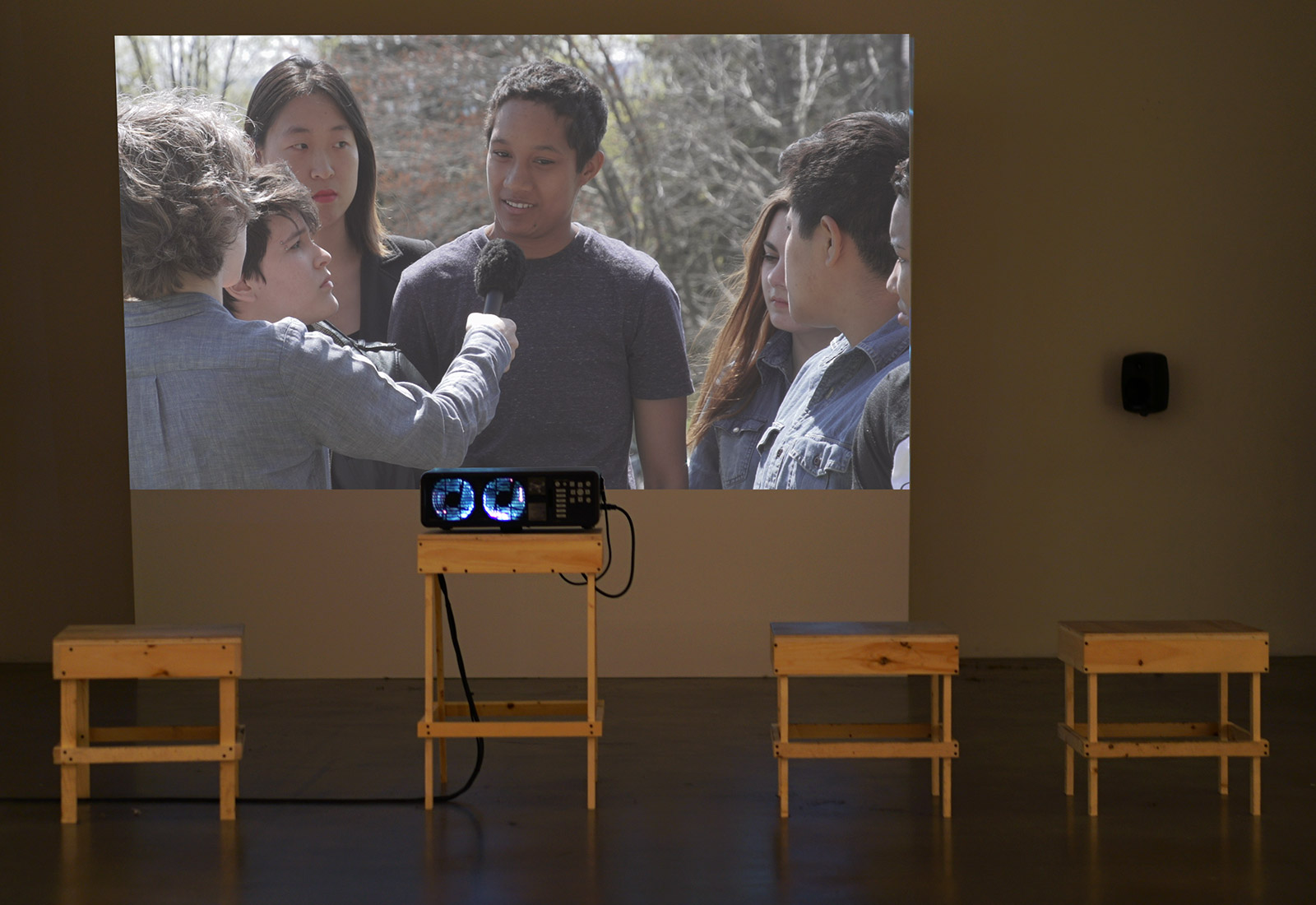 phot of a video art installation showing a group of young people being interviewed