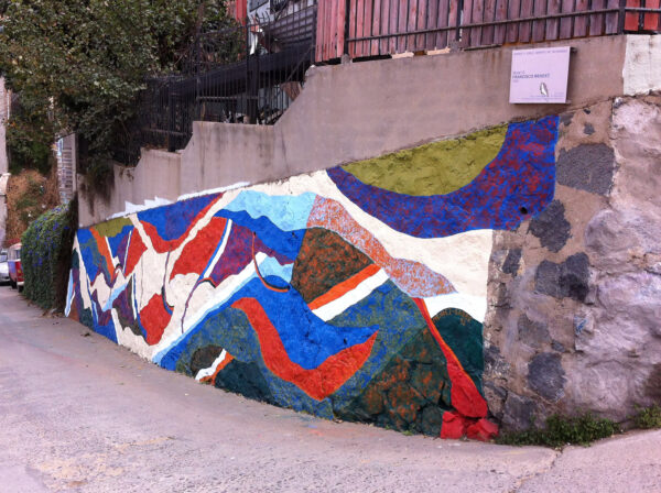 A mural painted on an outdoor wall of a sloped city street