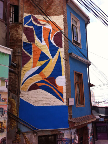 A brightly colored mural on the side of a brick building
