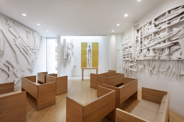 A room with large-scale artworks on the walls and wooden benches