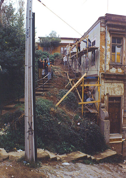 A group of people working on a mural on the side of a building