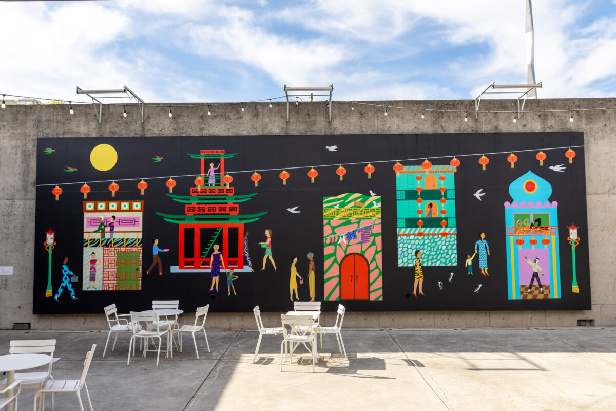 A brightly colored mural of a city neighborhood