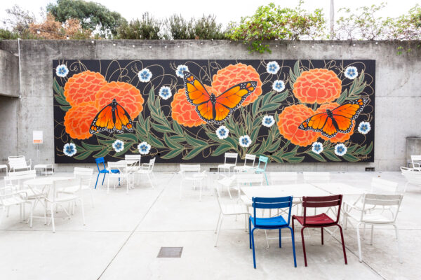 A mural of butterflies and flowers in an outdoor plaza