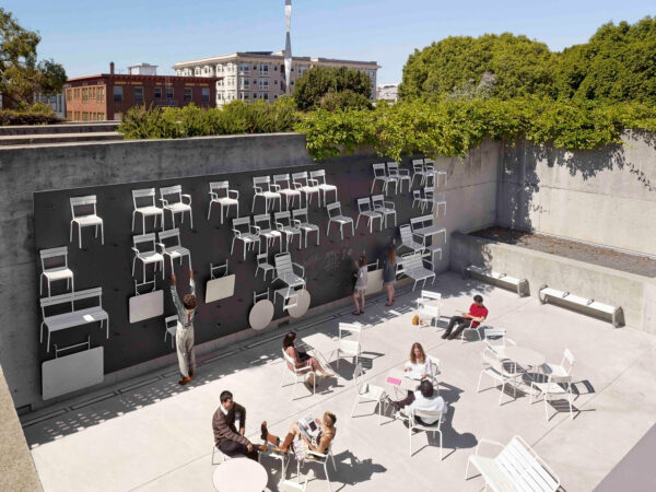 An outdoor wall with tables and chairs attached to it by hooks