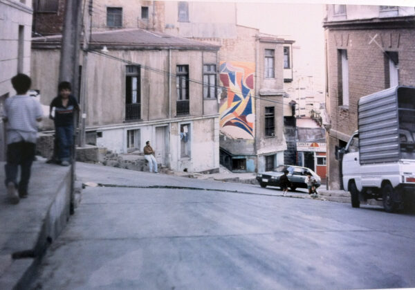 A building with a mural on it on the side of a city street