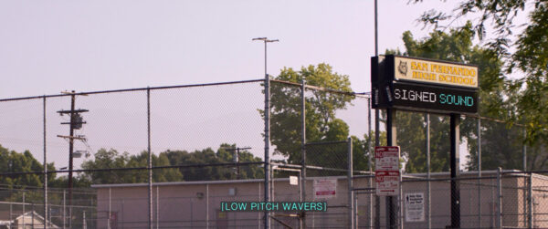 A large, outdoor fenced area with various signage